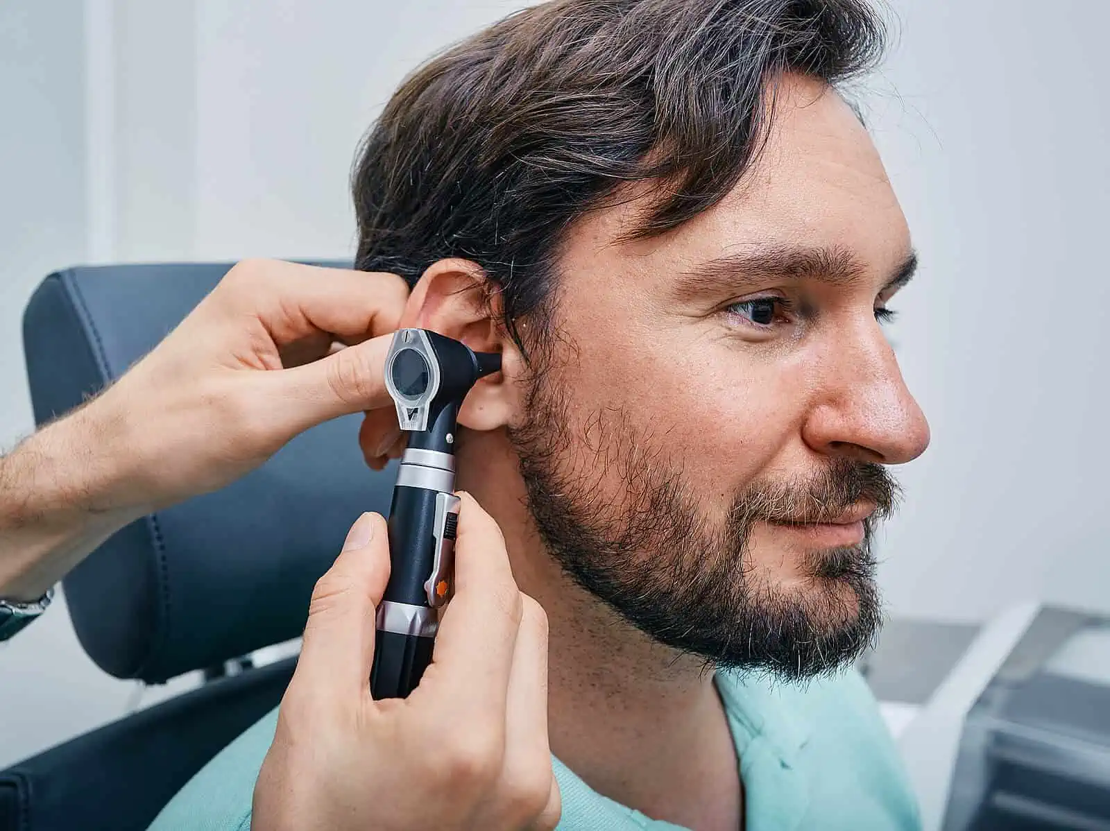 Man getting ear examined by audiologist