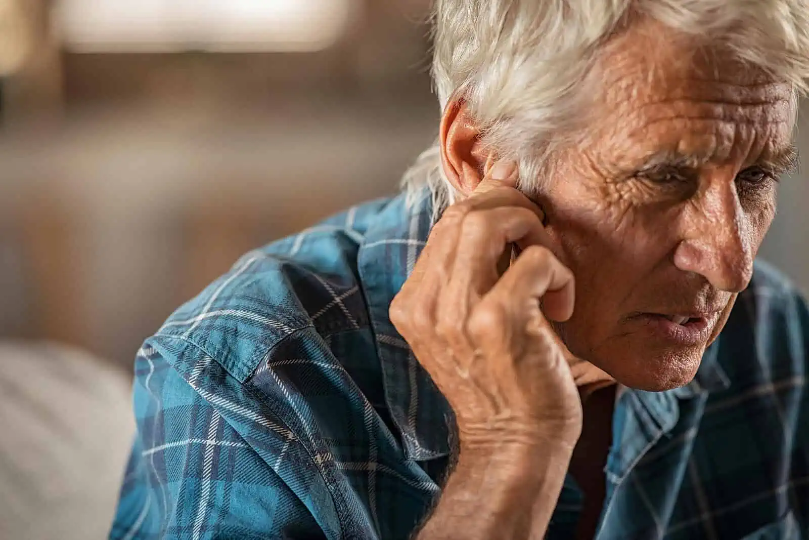 Elderly man in pain as he holds his ear