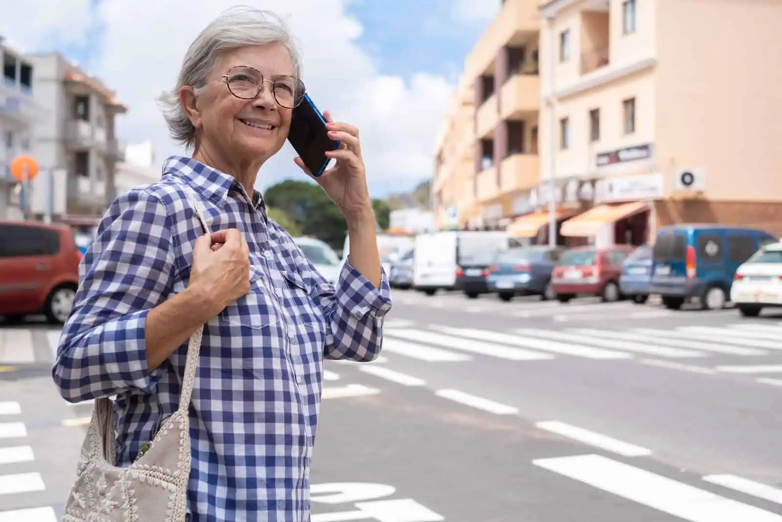 Elderly woman with hearing loss crossing a street